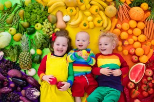 Small children surrounded by fruit and vegetables