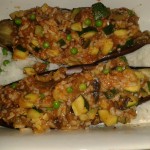 Use any leftover vegetables you have available to stuff aubergines.  These ones have rice, peas and mushrooms.